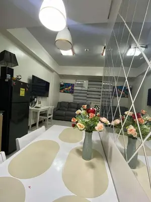 a room with a table with a vase of flowers on it at Vienna's Condotel in Manila