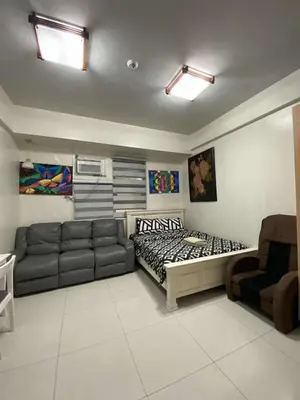 a living room with a bed and a couch at Vienna's Condotel in Manila