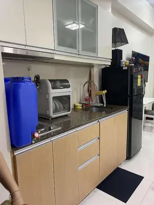 a small kitchen with a sink and a microwave at Vienna's Condotel in Manila