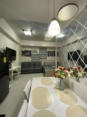 a living room with a white table with flowers on it at Vienna's Condotel in Manila