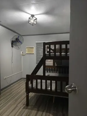 a room with a wooden staircase and a fan at AET Staycation House in San Pedro