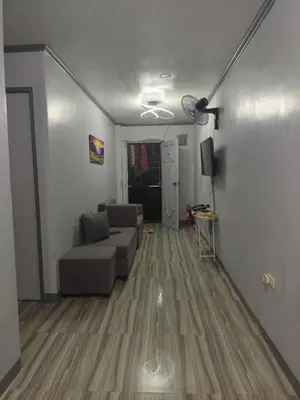 a living room with a couch and a tv at AET Staycation House in San Pedro
