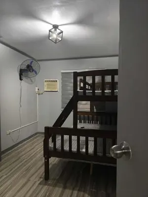 a room with a wooden staircase and a fan at AET Staycation House in San Pedro