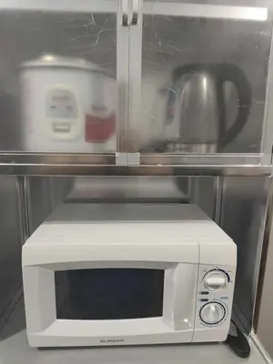 a white microwave sitting in a refrigerator at AET Staycation House in San Pedro