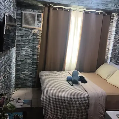 a bedroom with a bed with a hat on it at pierrecondotel in Manila
