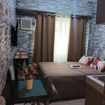 a small room with a bed and a window at pierrecondotel in Manila