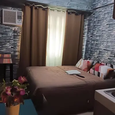 a bedroom with a bed with a laptop on it at pierrecondotel in Manila