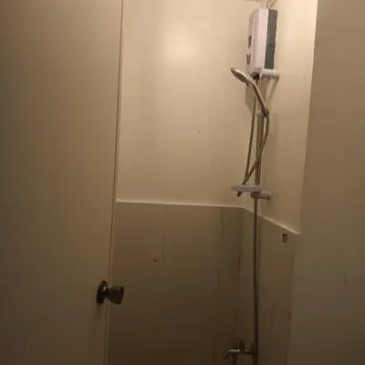 a bathroom with a shower with a glass door at pierrecondotel in Manila