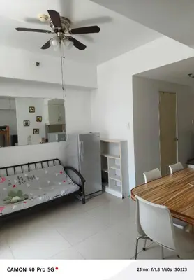 a room with a bed and a table and a ceiling fan at Moa view sea Residences condotel in Manila