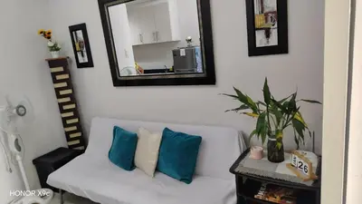 a living room with a white couch with blue pillows at Moa view sea Residences condotel in Manila
