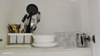 a shelf with utensils and glass jars on it at Moa view sea Residences condotel in Manila