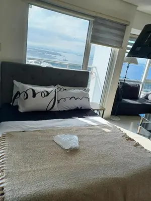 a bedroom with a bed with a large window at Your Home Near the Airport in Manila