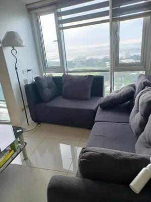 a living room with a couch and a large window at Your Home Near the Airport in Manila