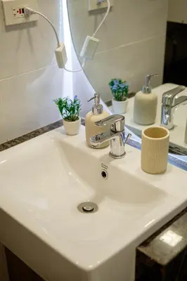 a bathroom sink with a faucet and a mirror at Modern & Stylish Condo at One Uptown Residence in Manila