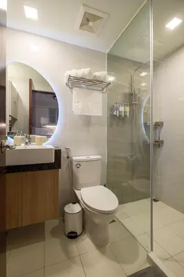 a bathroom with a toilet and a sink and a shower at Modern & Stylish Condo at One Uptown Residence in Manila