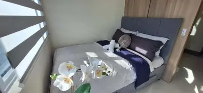 a bedroom with a bed with white flowers on it at JCs Staycation Fame Residences in Manila
