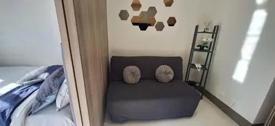 a bedroom with a chair next to a bed at JCs Staycation Fame Residences in Manila