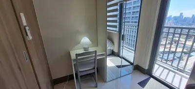 a table and chair in a room with a view of a city at JCs Staycation Fame Residences in Manila