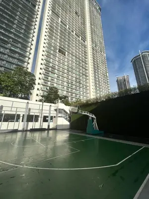 a tennis court in front of some tall buildings at Roomi Stays Acqua Private Residences in Manila