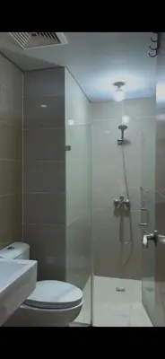 a bathroom with a shower and a toilet and a sink at Tala Vera condotel at Newport Pasay in Manila