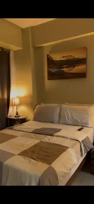 a bedroom with a large white bed in a room at Tala Vera condotel at Newport Pasay in Manila