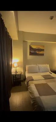 a bedroom with two beds and a table with a lamp at Tala Vera condotel at Newport Pasay in Manila