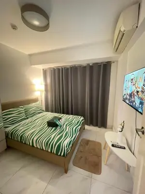 a small bedroom with a bed and a television at D'Hauz 2- Pet Friendly unit in Manila
