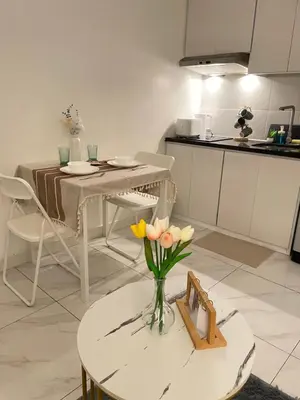 a kitchen with a table with a vase of flowers on it at D'Hauz 2- Pet Friendly unit in Manila