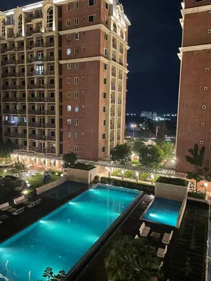 a swimming pool in front of a building at night at D'Hauz 2- Pet Friendly unit in Manila