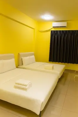 two beds in a room with yellow walls at T1 Stay Airport Residences - Tower A in Manila