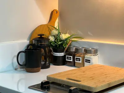 a kitchen counter with a coffee pot and spices at Prime Makati CBD Condo with Fast WiFi in Manila