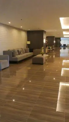 a living room with couches and tables in a building at Prime Makati CBD Condo with Fast WiFi in Manila