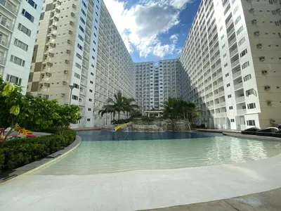 a swimming pool in the middle of two tall buildings at Cozy 1 BR unit at Shore 1 Residences Mall of Asia in Manila