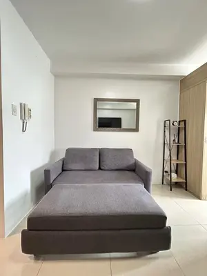 a large bed in a white room with a mirror at Cozy 1 BR unit at Shore 1 Residences Mall of Asia in Manila