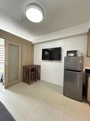 a kitchen with a refrigerator and a small table at Cozy 1 BR unit at Shore 1 Residences Mall of Asia in Manila
