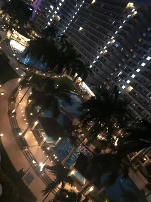 a group of palm trees in front of a tall building at Staycation by Jia cozy corner in Manila