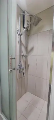 a shower with a glass door in a bathroom at Staycation by Jia cozy corner in Manila