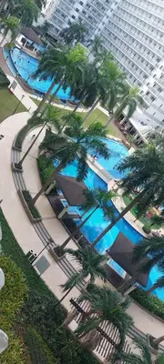 an overhead view of a pool with palm trees and buildings at Staycation by Jia cozy corner in Manila
