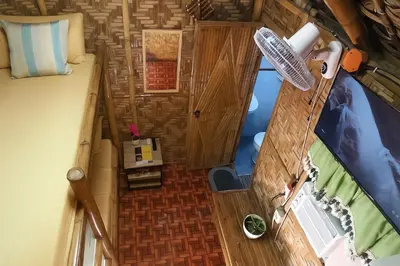 an overhead view of a bedroom and a bed in a tiny house at CLBC Bahay Kubo in Tagapo