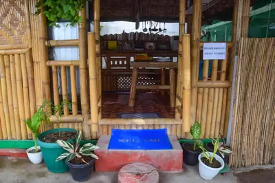 a room with potted plants in front of a building at CLBC Bahay Kubo in Tagapo