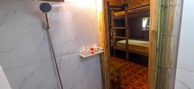 a room with a shower with candles on the wall at CLBC Bahay Kubo in Tagapo