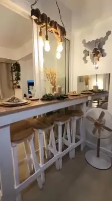 a kitchen with a large white counter with stools at Azure SYM Staycation in Manila