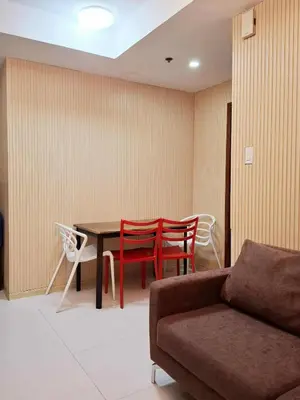 a living room with a couch and a table and chairs at Sunshine100 1Bedroom 65InchesTV PoolGymBilliardPlayground in Manila