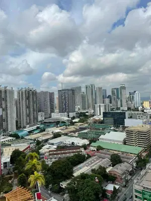 a city skyline with tall buildings in the distance at Sunshine100 1Bedroom 65InchesTV PoolGymBilliardPlayground in Manila