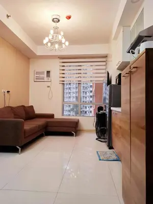 a living room with a couch and a television at Sunshine100 1Bedroom 65InchesTV PoolGymBilliardPlayground in Manila