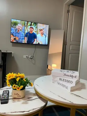 a living room with a tv and a table with flowers at D'Hauz 3 - Pet Friendly unit in Manila