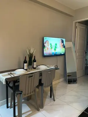 a dining room with a table and a tv on the wall at D'Hauz 3 - Pet Friendly unit in Manila