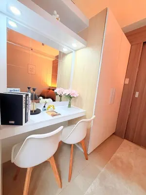 a room with a desk and two white chairs at Bayshore Getaway Condotel by Clowie in Manila