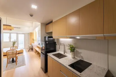 a kitchen with a black refrigerator and a sink at Luxury 1 BR City View in Park Mckinley West Fast Wi-Fi Washer Dryer in Manila
