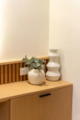 two white vases sitting on top of a wooden cabinet at Luxury 1 BR City View in Park Mckinley West Fast Wi-Fi Washer Dryer in Manila